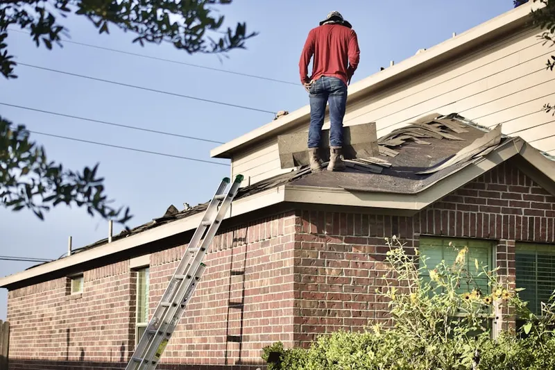 Professional roofer working on a residential roof in White Lake